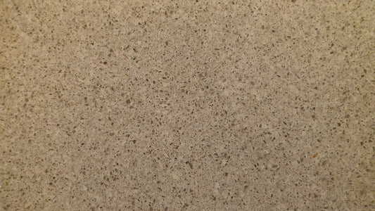 A close-up of a plain beige speckled kitchen countertop surface, no people