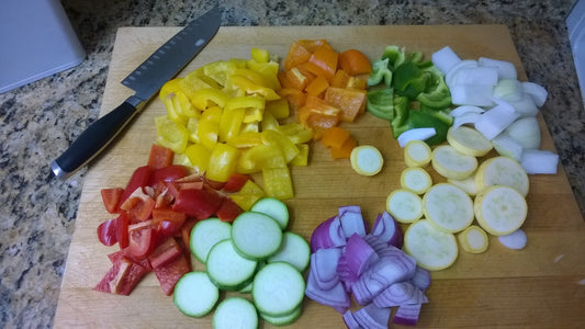 Chopped vegetables arranged in separate groups on a wooden cutting board