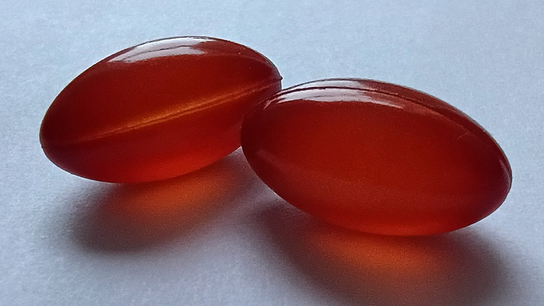 Plain amber supplement capsules arranged on a white surface