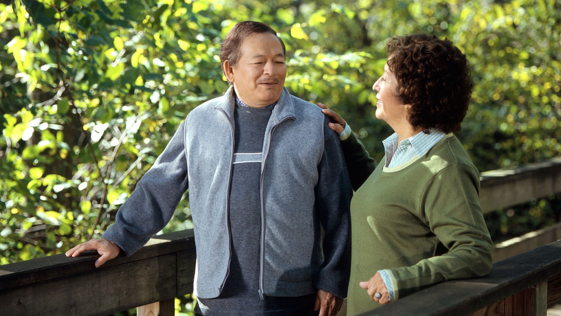 Older couple enjoying an easy walk on a wooded bridge