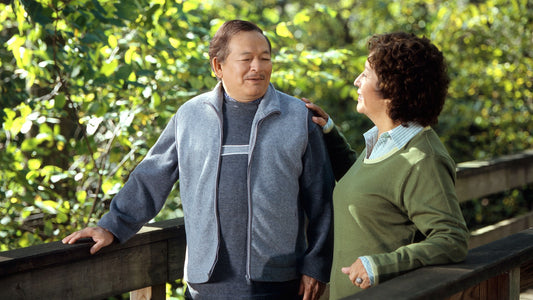 Older couple enjoying an easy walk on a wooded bridge