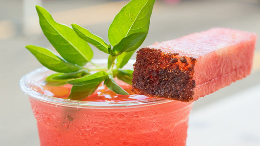Chilled pink fruit drink with green herb garnish