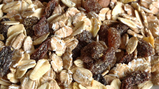 Close-up of rolled oats, raisins, nuts, and grains in a dry muesli mix