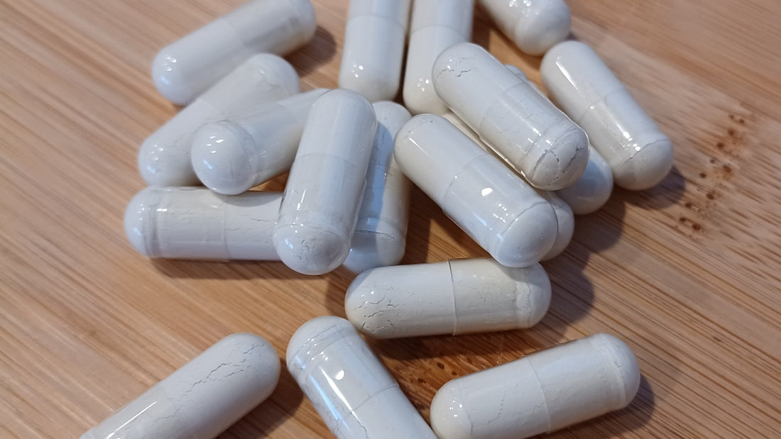 White supplement capsules on a wooden surface