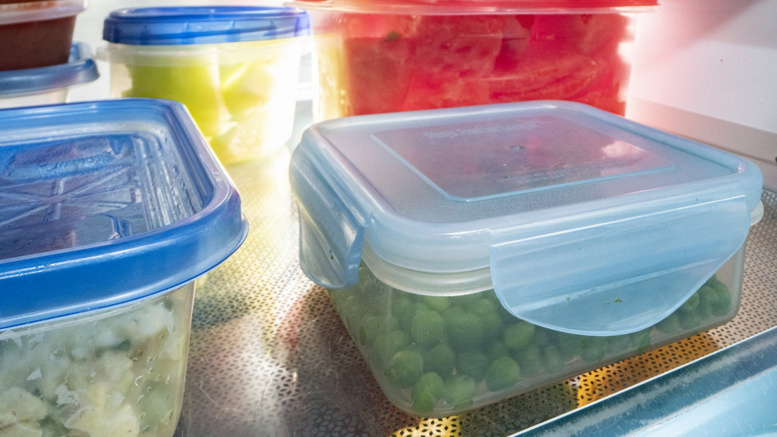 Clear food containers with prepared vegetables on a refrigerator shelf