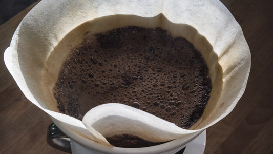 Overhead view of a manual pour-over coffee brewing on a wooden table