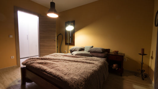 Cozy bedroom interior with warm amber lamp light and soft bedding