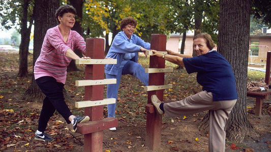 Older women stretching outdoors as part of a mobility routine.