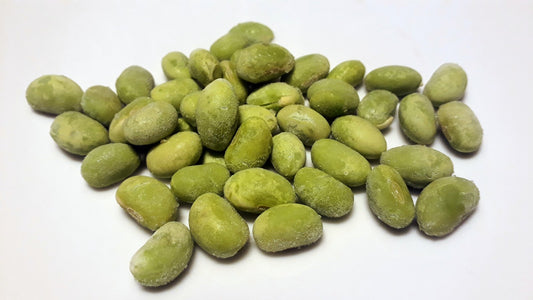 Frozen green soybeans scattered on a white surface