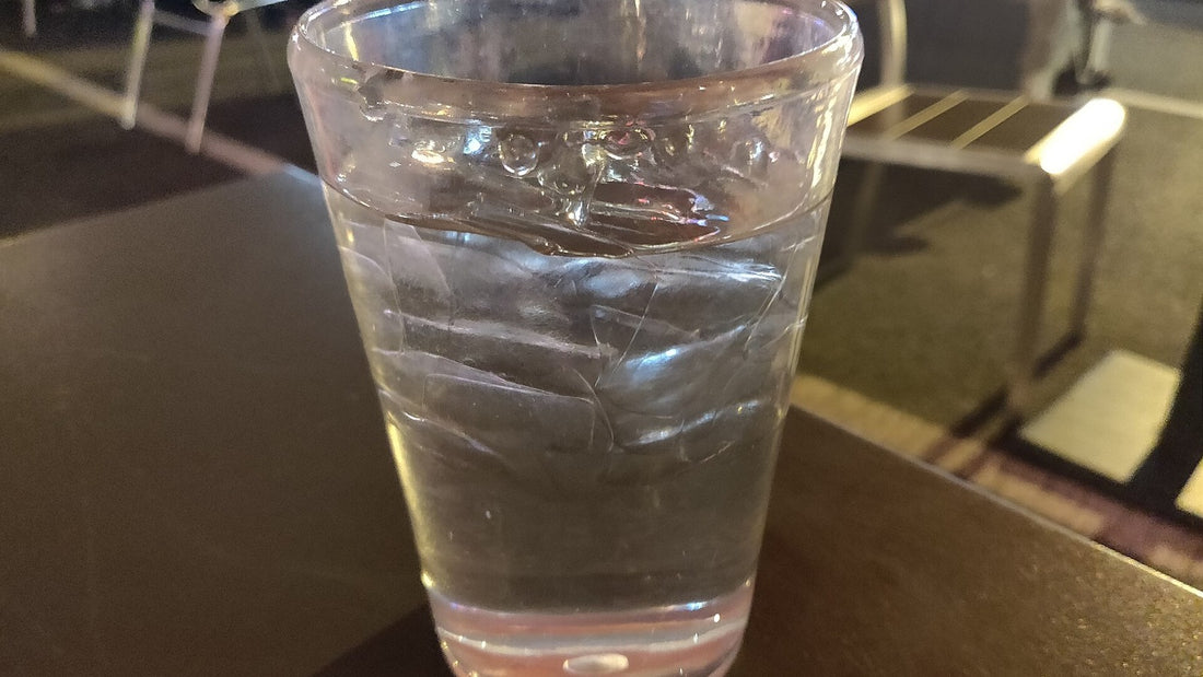 Clear glass of ice water on an outdoor table