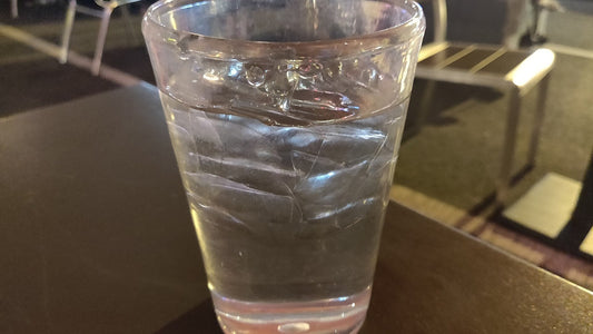 Clear glass of ice water on an outdoor table