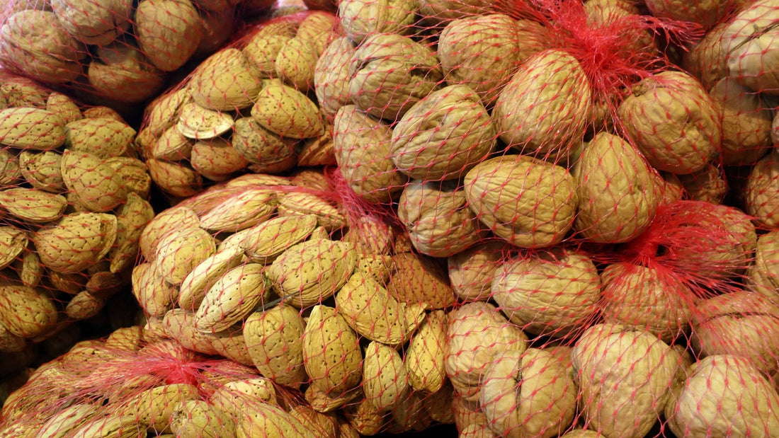 Almonds and walnuts gathered in simple mesh produce bags