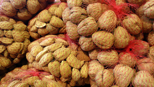 Almonds and walnuts gathered in simple mesh produce bags