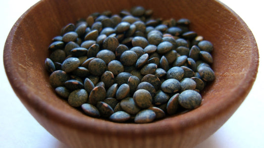 Close-up of dried lentils in a small wooden bowl