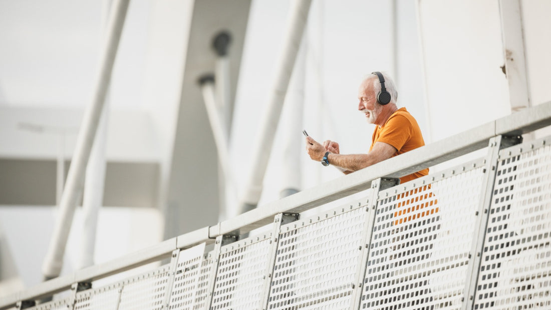 Older man checking his phone on a bright pedestrian walkway before a short walk