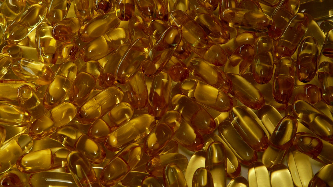 A pile of golden softgel supplement capsules