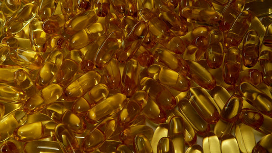 A pile of golden softgel supplement capsules