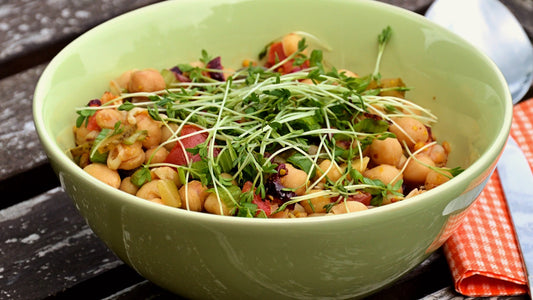 Chickpea salad with garden cress in a green bowl