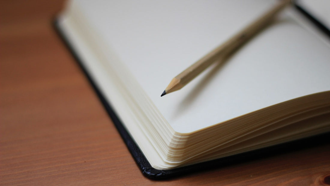 Blank notebook with a pencil on a wooden table