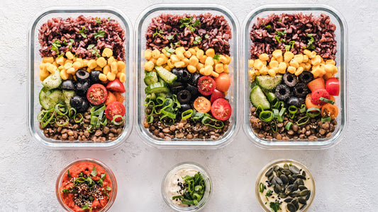 Glass meal-prep containers filled with grains and vegetables