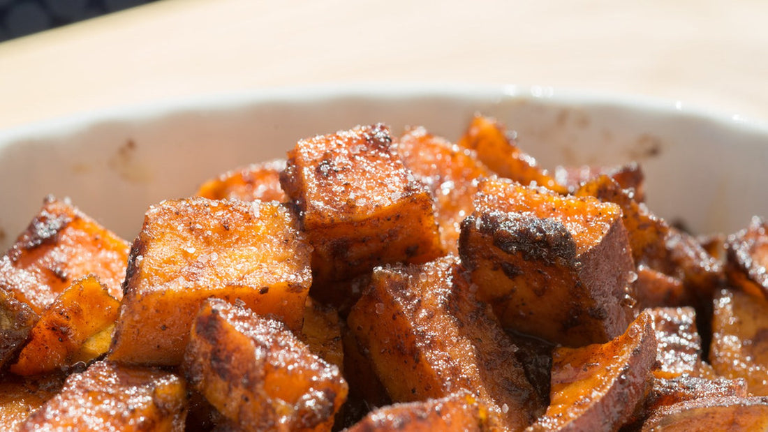 Close-up of seasoned roasted sweet potato cubes in a serving bowl